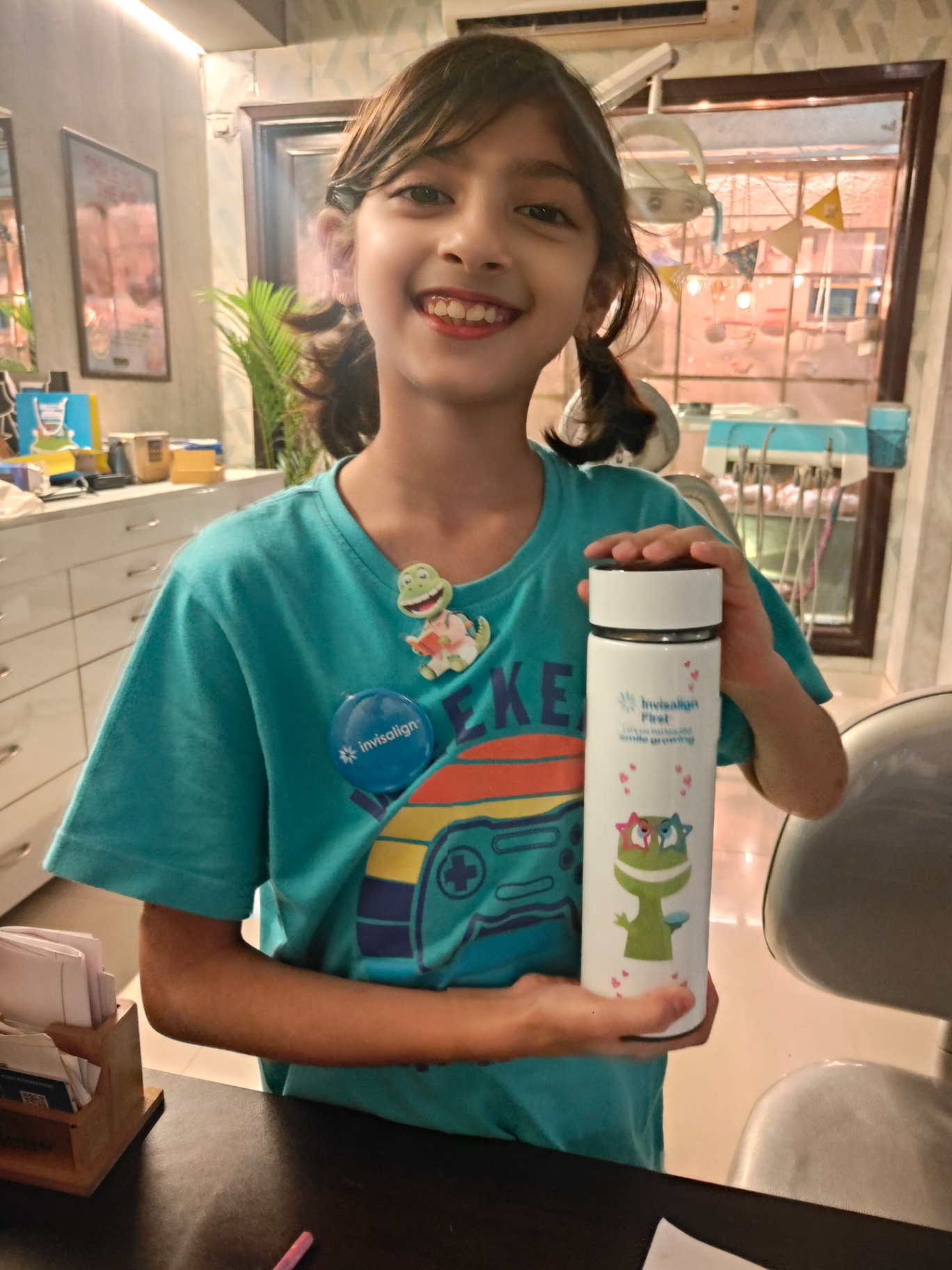 Child smiling with her Invisalign First bottle