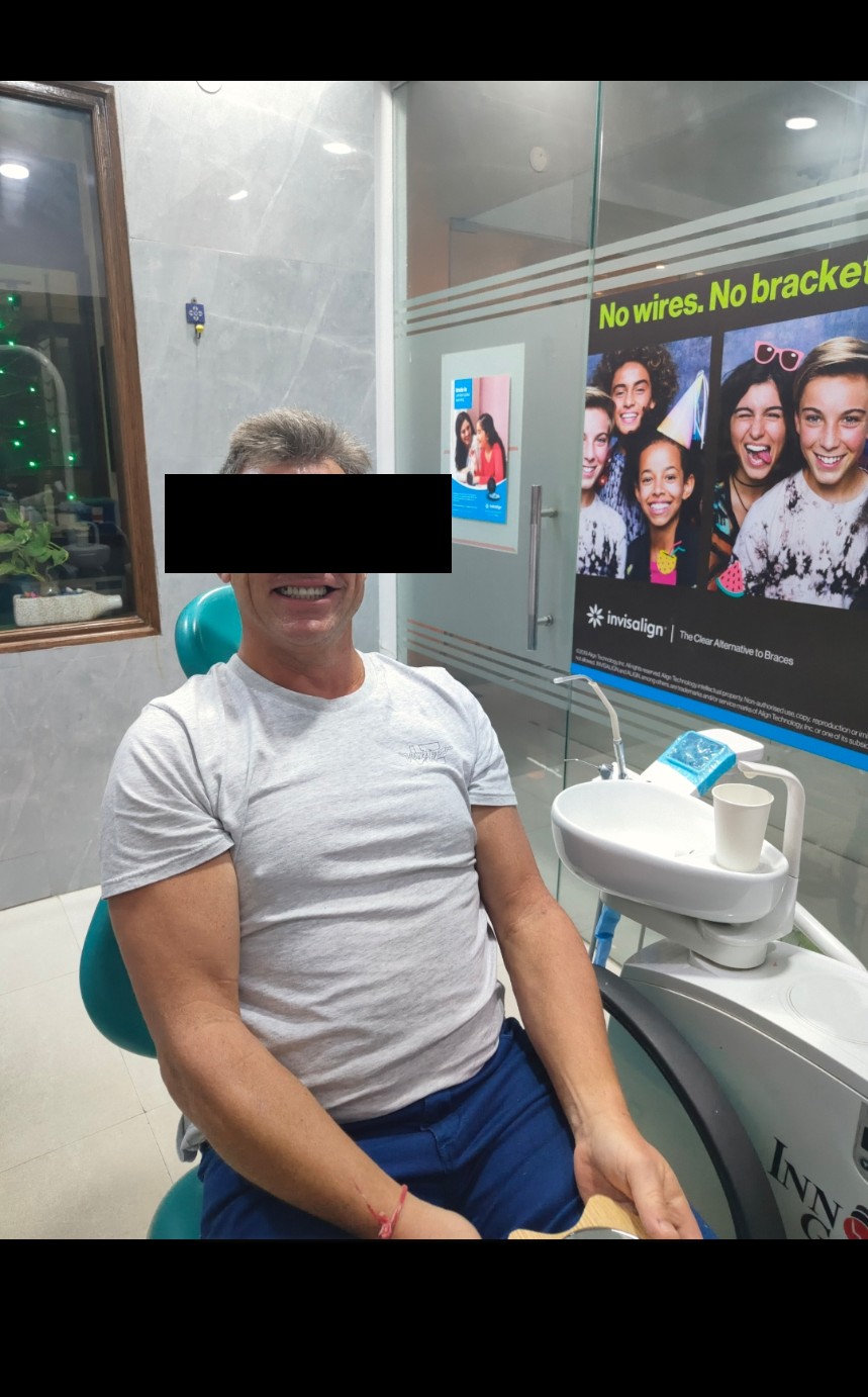 Australian patient smiling in the dental chair after upper-arch rehabilitation — identity protected