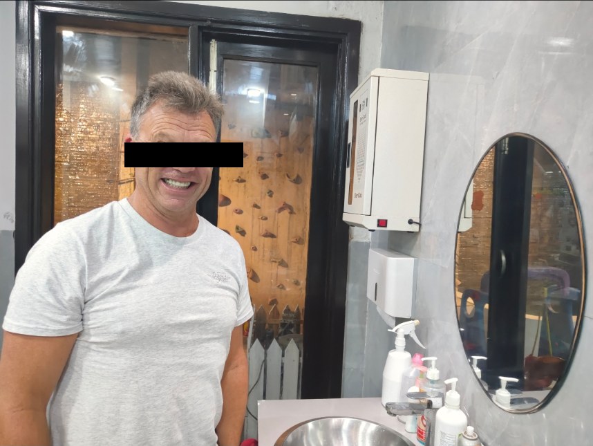 Australian patient standing comfortably in the clinic during treatment — eyes masked for privacy