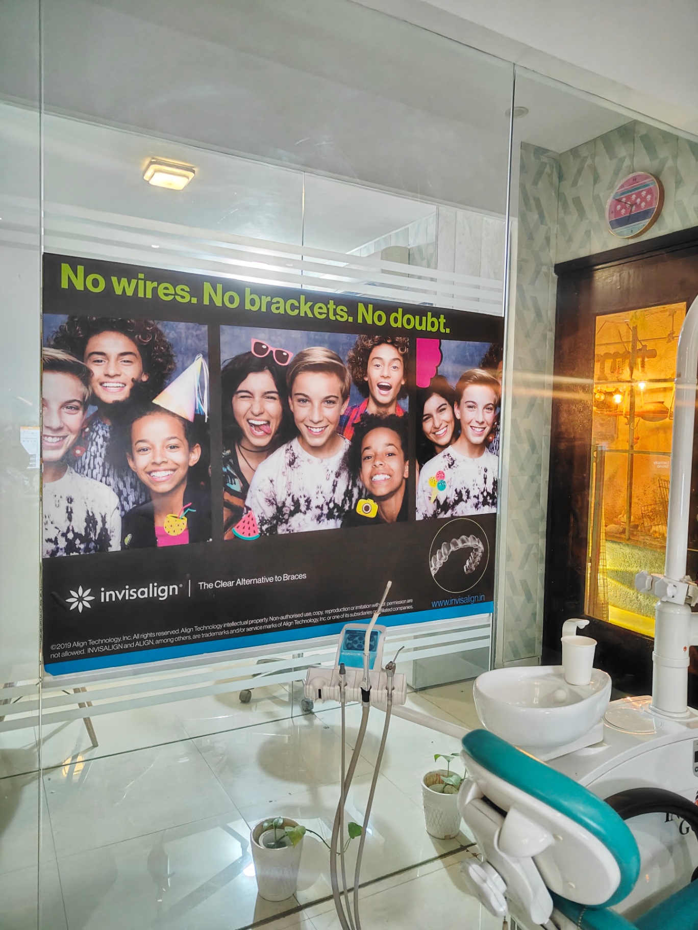 Indian teenagers laughing together, one holding a clear aligner