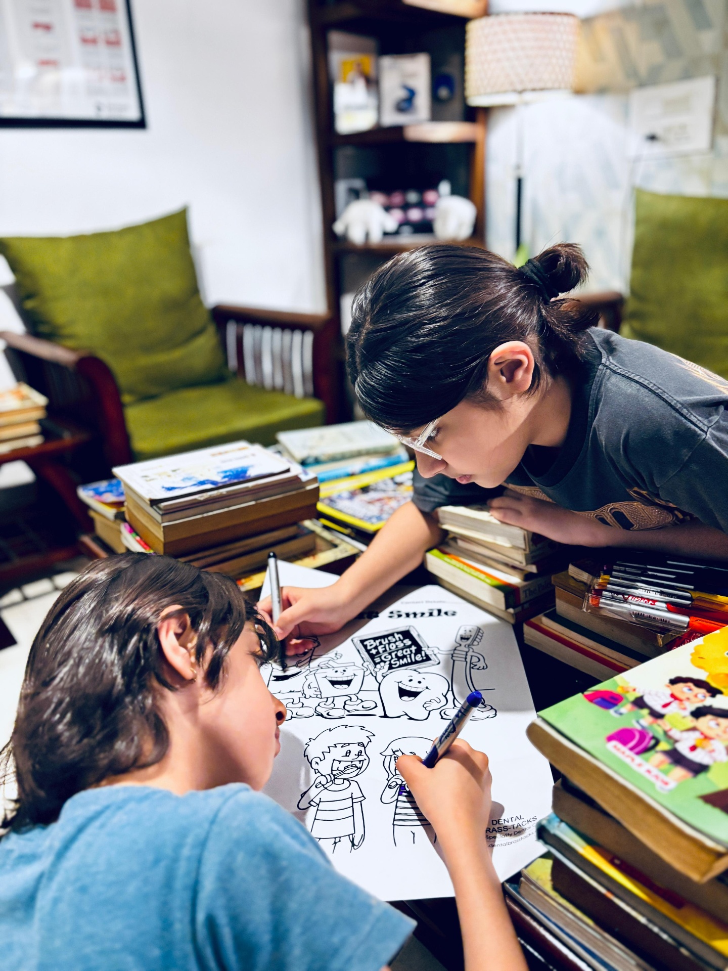Two children colouring Dental Brasstacks 'Brush, Floss, Great Smile' sheets in the in-house library in Gurgaon