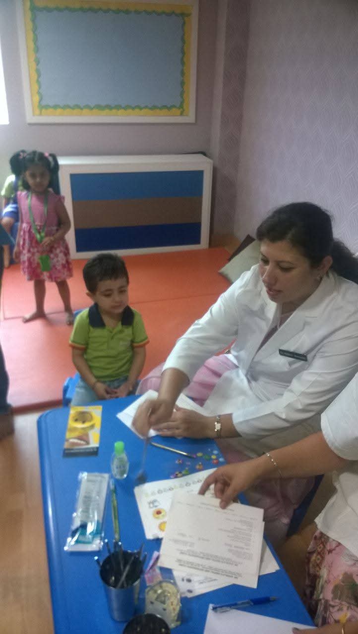 Dr. Nisha Bali gently examining a toddler at a preschool dental screening