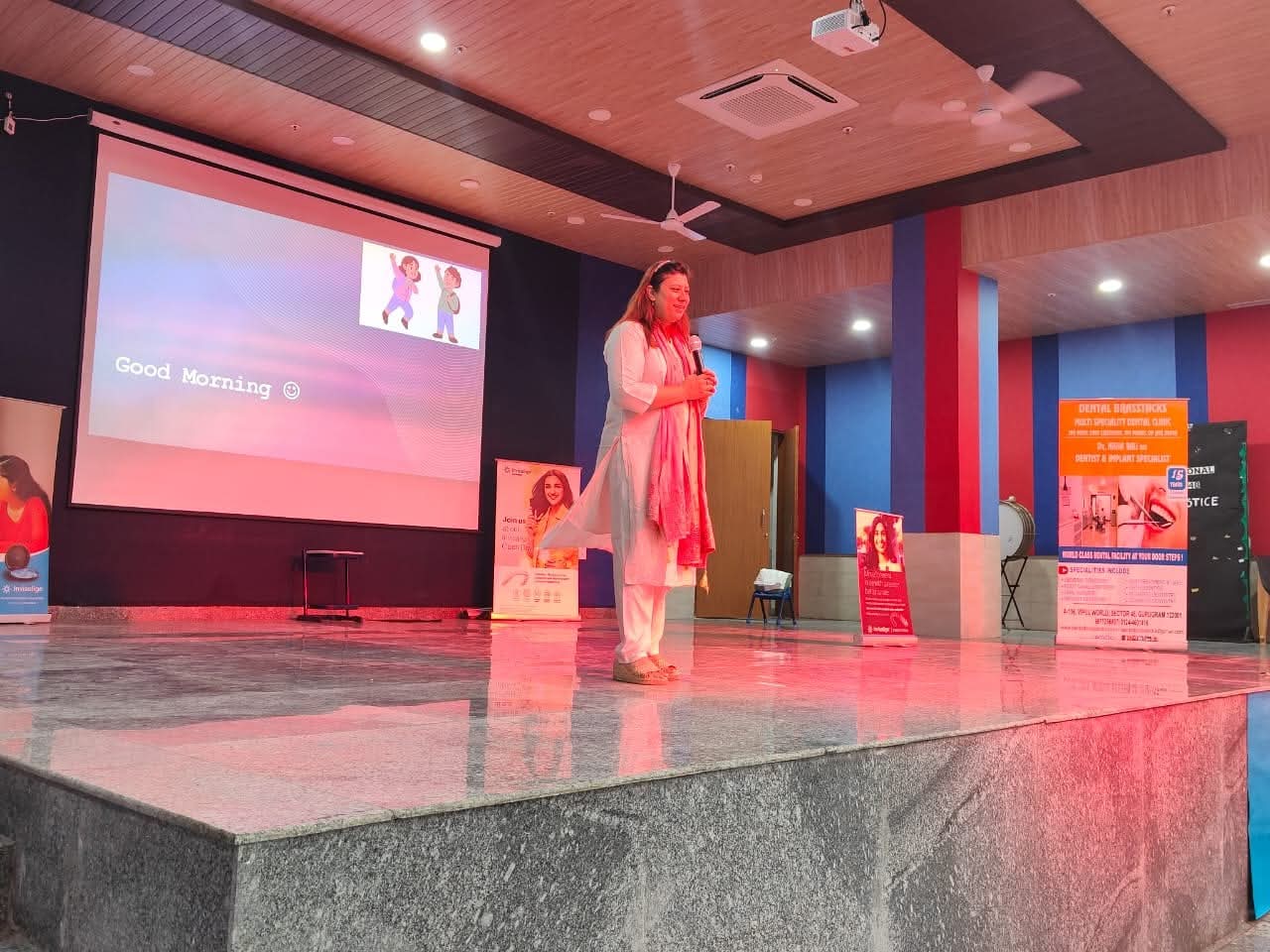 Dr. Nisha Bali presenting a dental awareness session on stage at a Gurgaon school